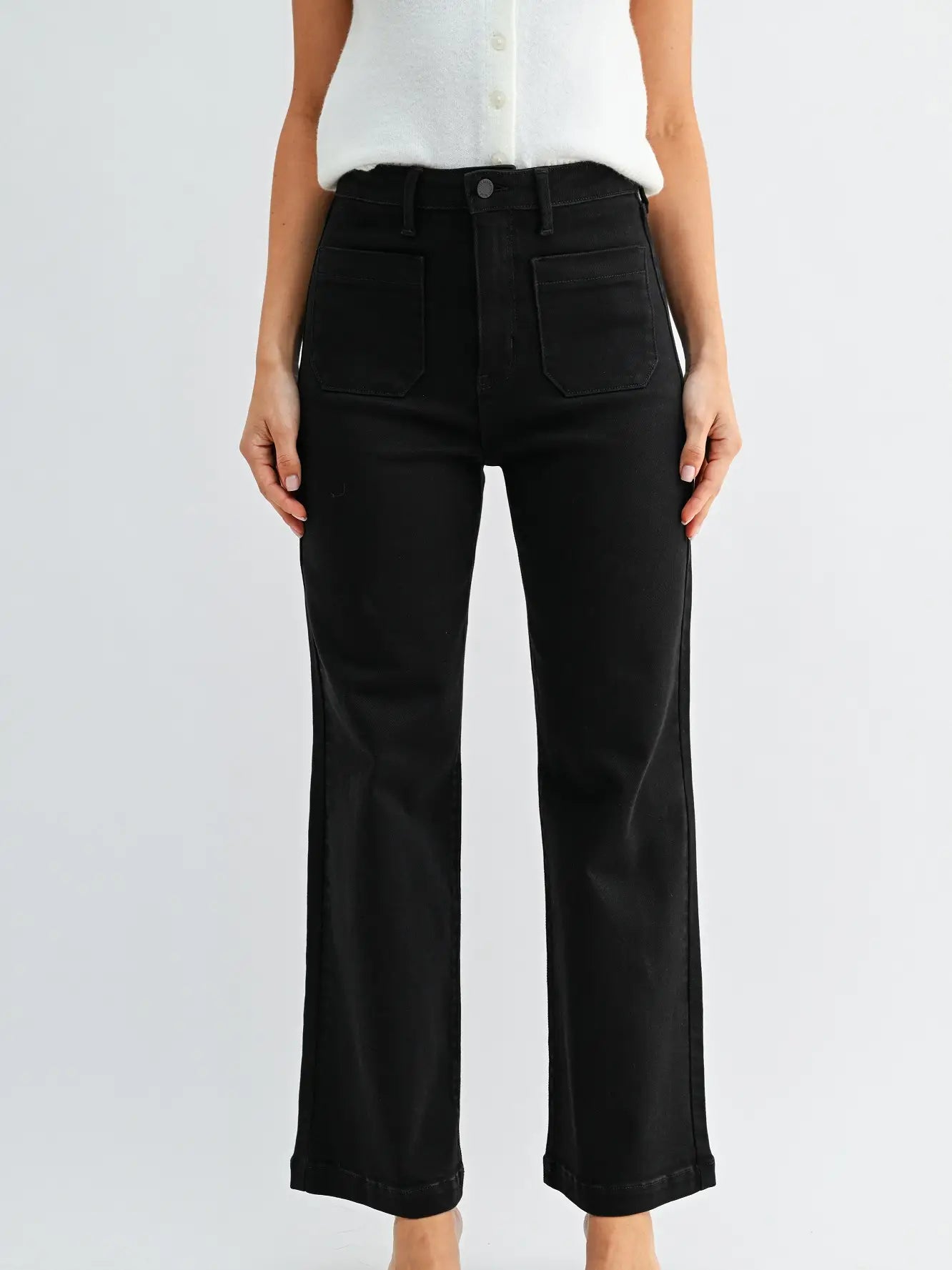 Person wearing black pants and a white shirt on a light gray background