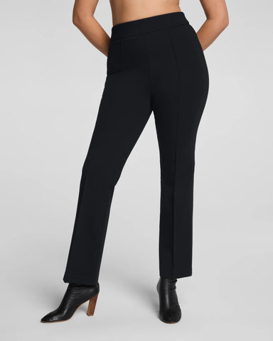 Black pants worn by a person on a plain background