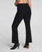 Black high-waisted flared pants shown on a model from the back, paired with black ankle boots, against a light gray studio background.
