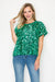 Woman wearing a green sequin top and blue jeans on a white background