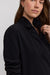 Woman wearing a black jacket against a white background