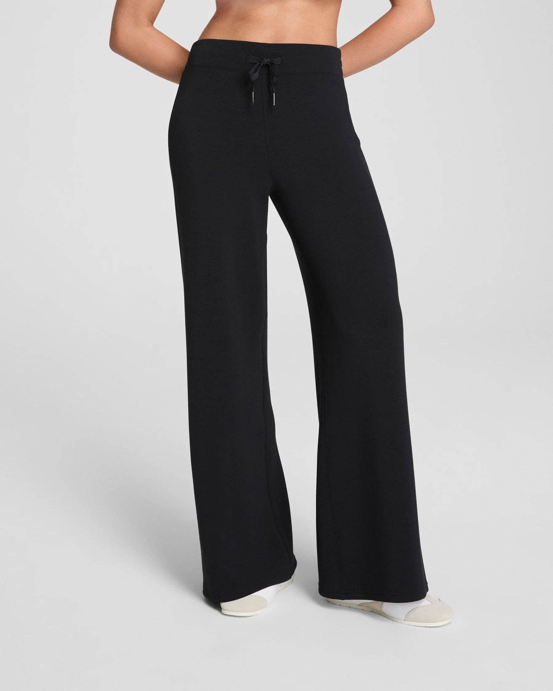 Black wide-leg pants worn by a person on a light gray background