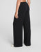 Black wide-leg pants worn by a person on a light gray background