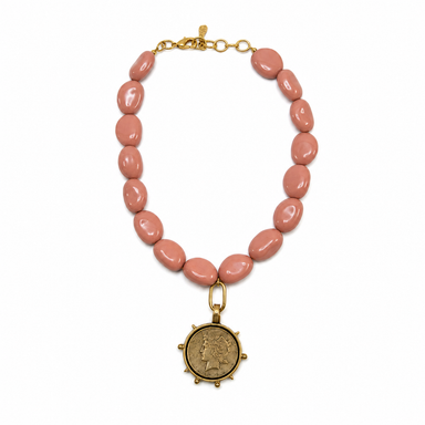 Necklace with pink beads and a gold coin pendant on a white background