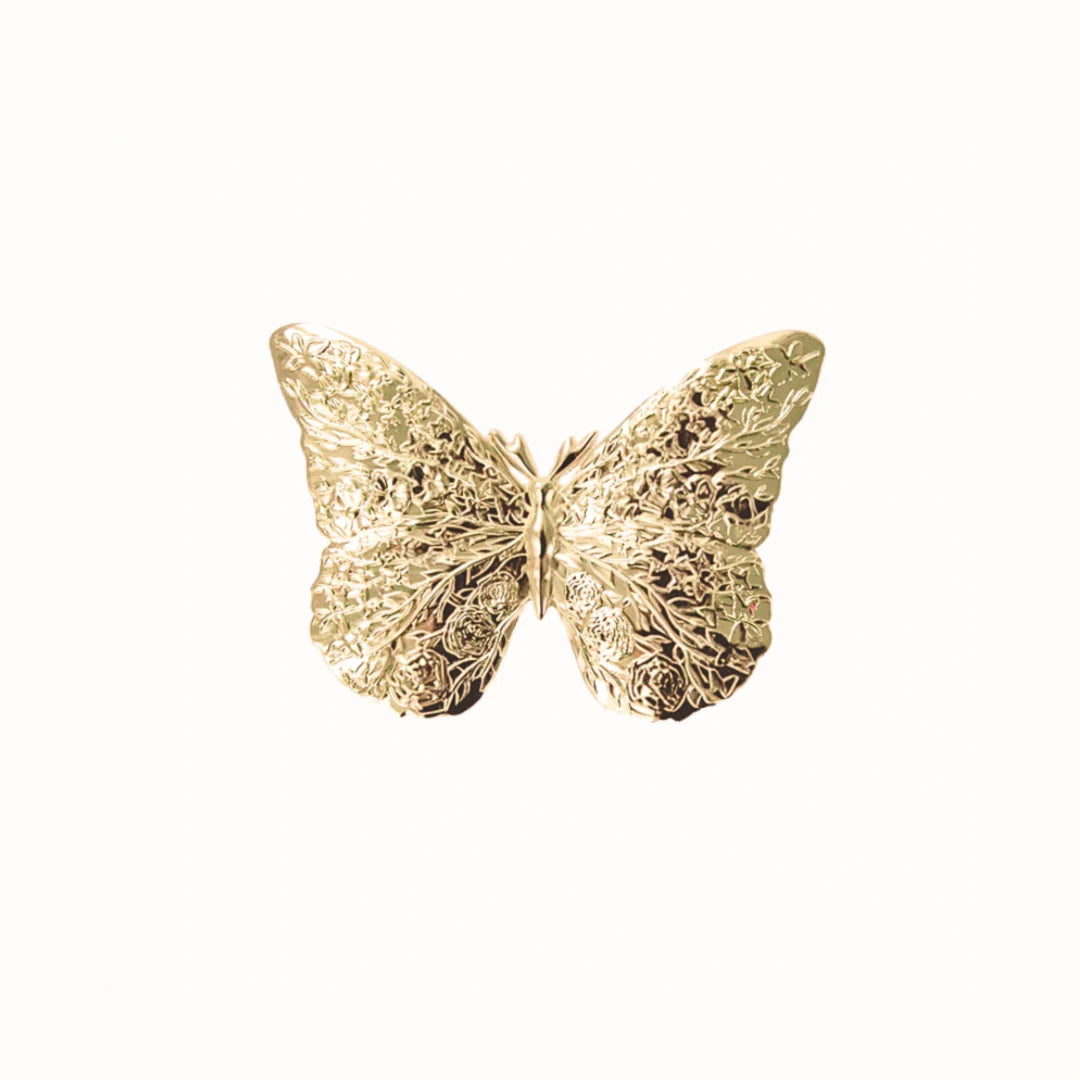 Gold butterfly-shaped decorative piece on a white background
