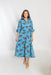 Woman wearing a blue dress with bird pattern on a white background
