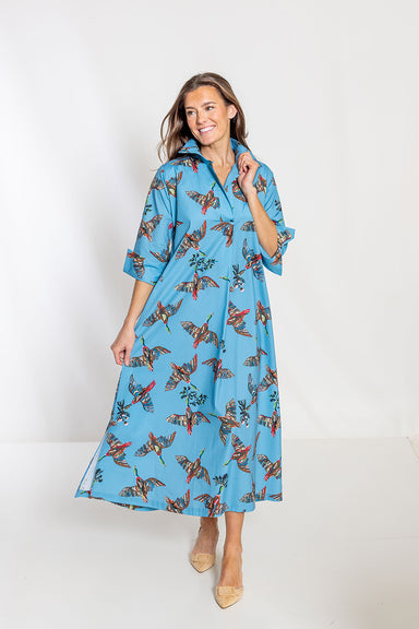 Woman wearing a blue dress with a floral pattern on a white background