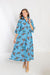 Woman wearing a blue dress with a floral pattern on a white background