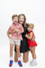 A woman and two children posing together against a solid white studio background. The woman is kneeling on one knee, wearing a black dress and smiling.