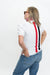 A woman shown from the back wearing a white short-sleeve polo shirt with vertical red and black stripes down the back, paired with blue jeans and sunglasses, against a plain white background.