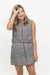 A woman modeling a sleeveless black and white gingham mini dress with red piping details, set against a plain white studio background.