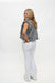 A woman with blonde hair is shown from a back-three-quarter angle, wearing a black and white gingham sleeveless top, white flared pants, and beige shoes, standing against a plain white studio background.
