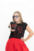 A woman wearing black sunglasses, a black graphic t-shirt with red line art, and a red skirt holds up a black cup with the word 'WOOF' printed in red, set against a plain white background.
