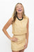 A woman laughing while wearing a yellow and white gingham sleeveless top and matching mini skirt, accessorized with a chunky black beaded necklace, against a plain white background.