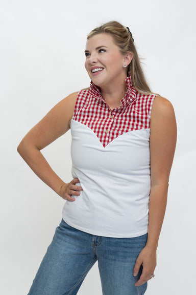 A woman modeling a sleeveless collared top with a red and white gingham yoke and a solid white body, paired with blue jeans, against a plain white studio background.