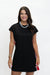 A woman modeling a black short-sleeve shift dress with red and white side stripes, paired with a chunky silver necklace and gold bracelets, against a plain white background.