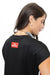 A woman shown from the back wearing a black t-shirt with a red rectangular patch that reads 'GO DAWGS' in white text.
