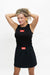 A woman modeling a black sleeveless tank top and matching black mini skirt set, both featuring a red rectangular patch on the chest and waist with the text 'GO BREATHE'.