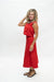 A woman modeling a sleeveless red dress with a cropped top and midi skirt, paired with black strappy sandals, against a plain white studio background.