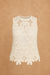 White crochet top on a beige background