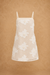Beige lace dress with white floral patterns on a brown background