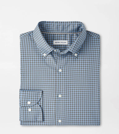 Folded blue and green checkered shirt with 'Peter Millar' label on a light gray background
