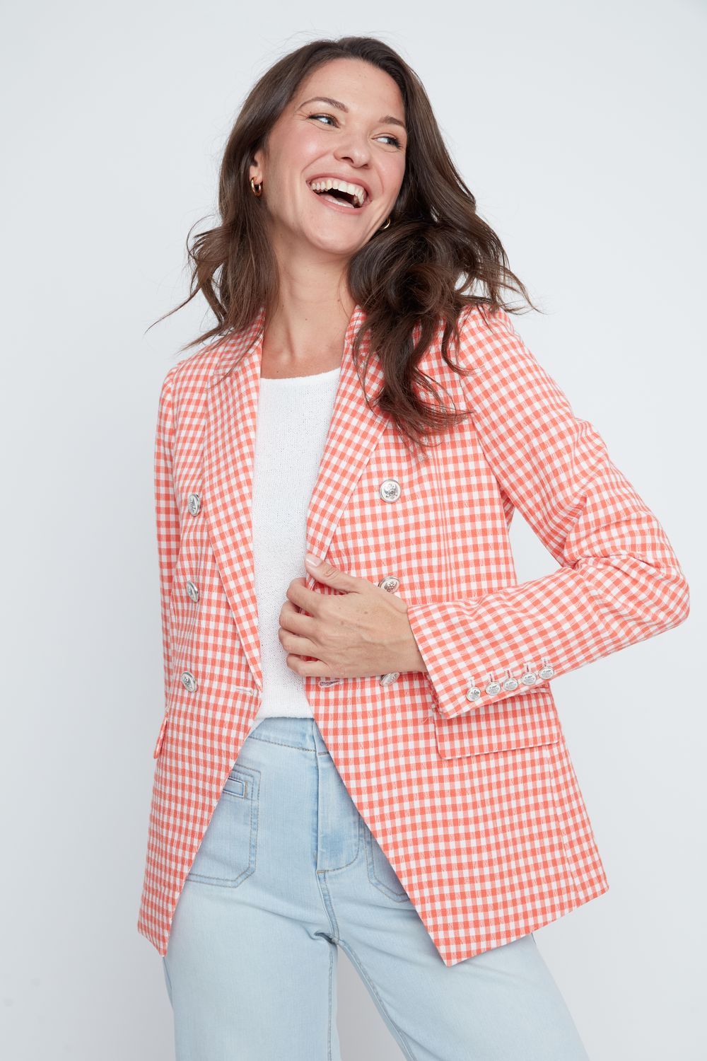 Woman wearing a red and white checkered blazer on a light gray background