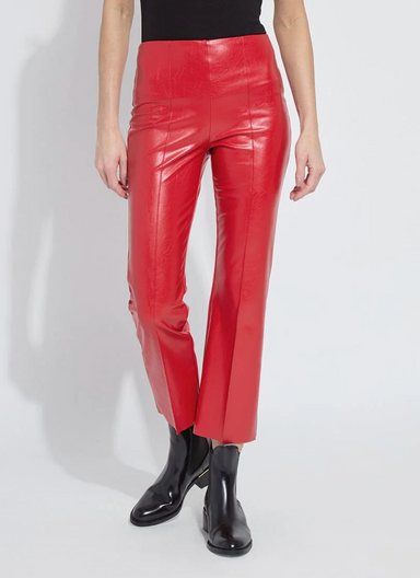 Person wearing red vinyl pants and black shoes on a white background