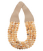 Necklace with beige and white beads on a beige holder against a white background