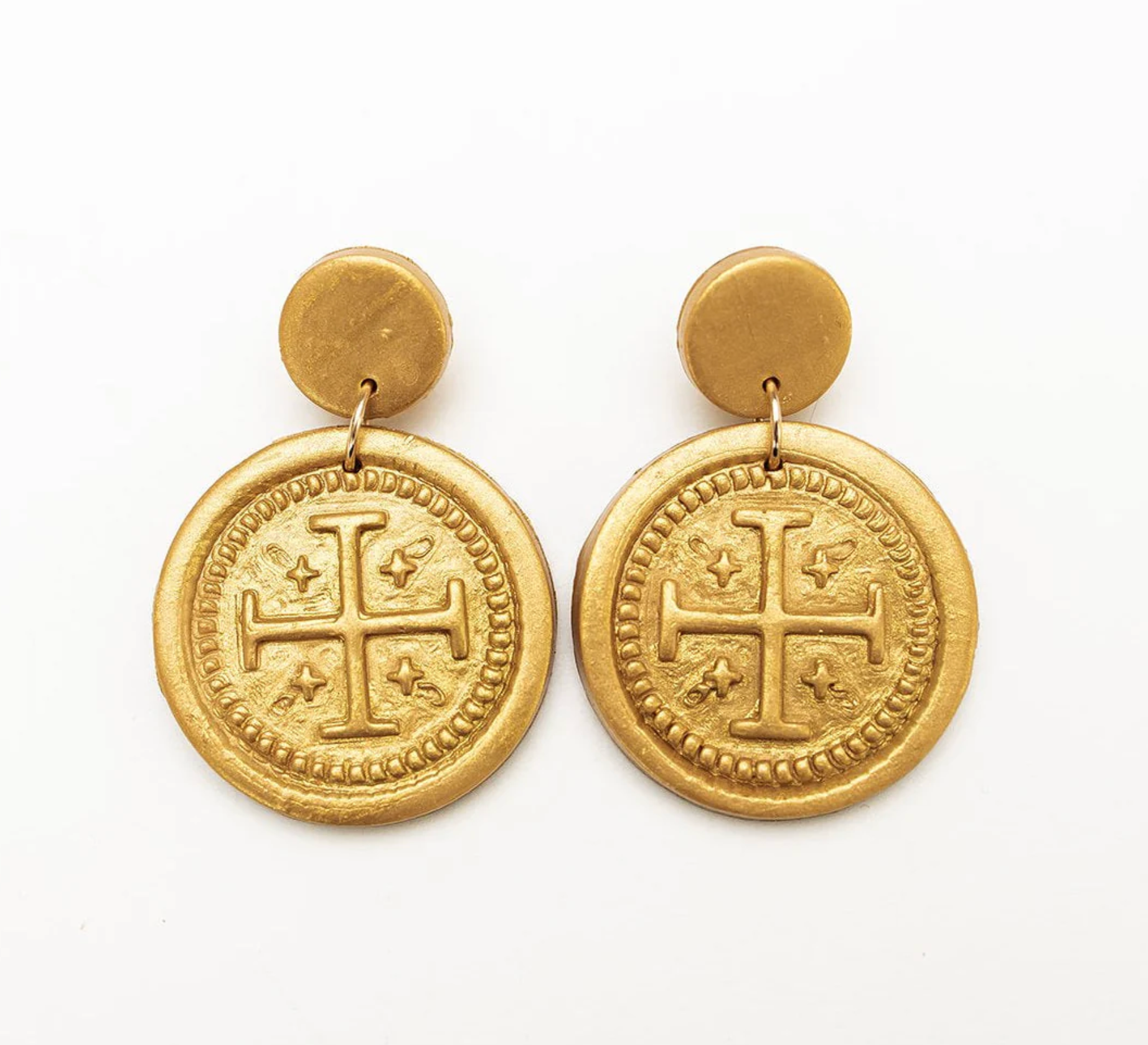 Gold coin-shaped earrings with a cross design on a white background