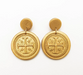 Gold coin-shaped earrings with a cross design on a white background