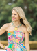 Woman wearing a colorful dress with a blurred green background