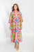 Woman wearing a colorful patterned dress on a white background