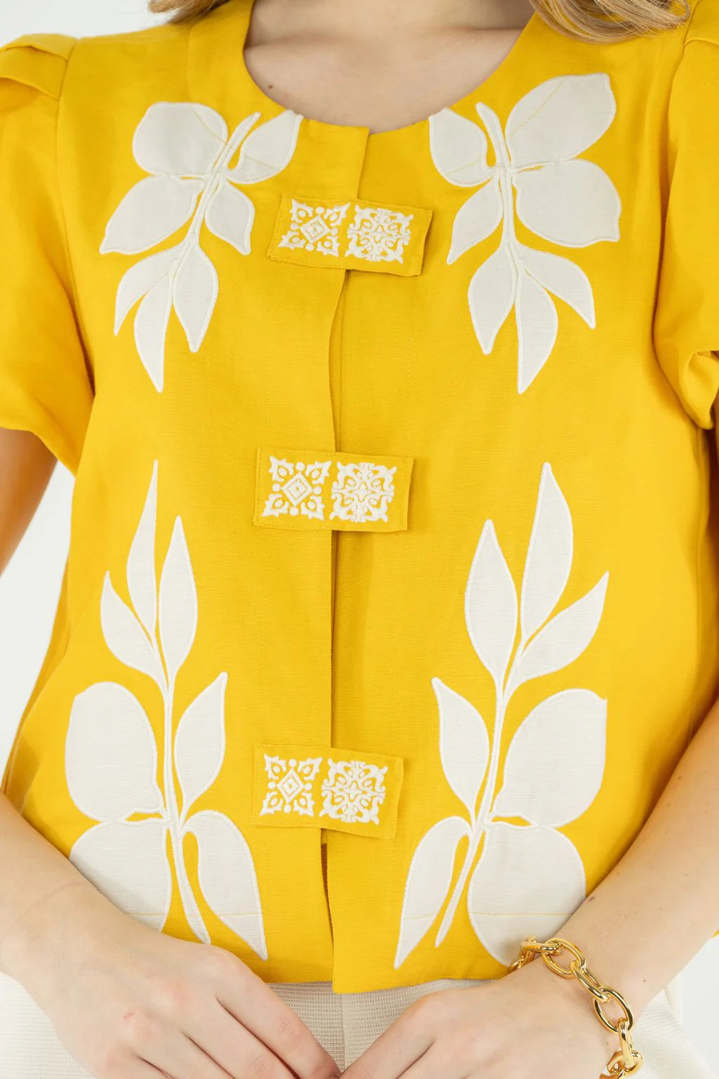 Yellow top with white floral patterns and QR codes on a white background