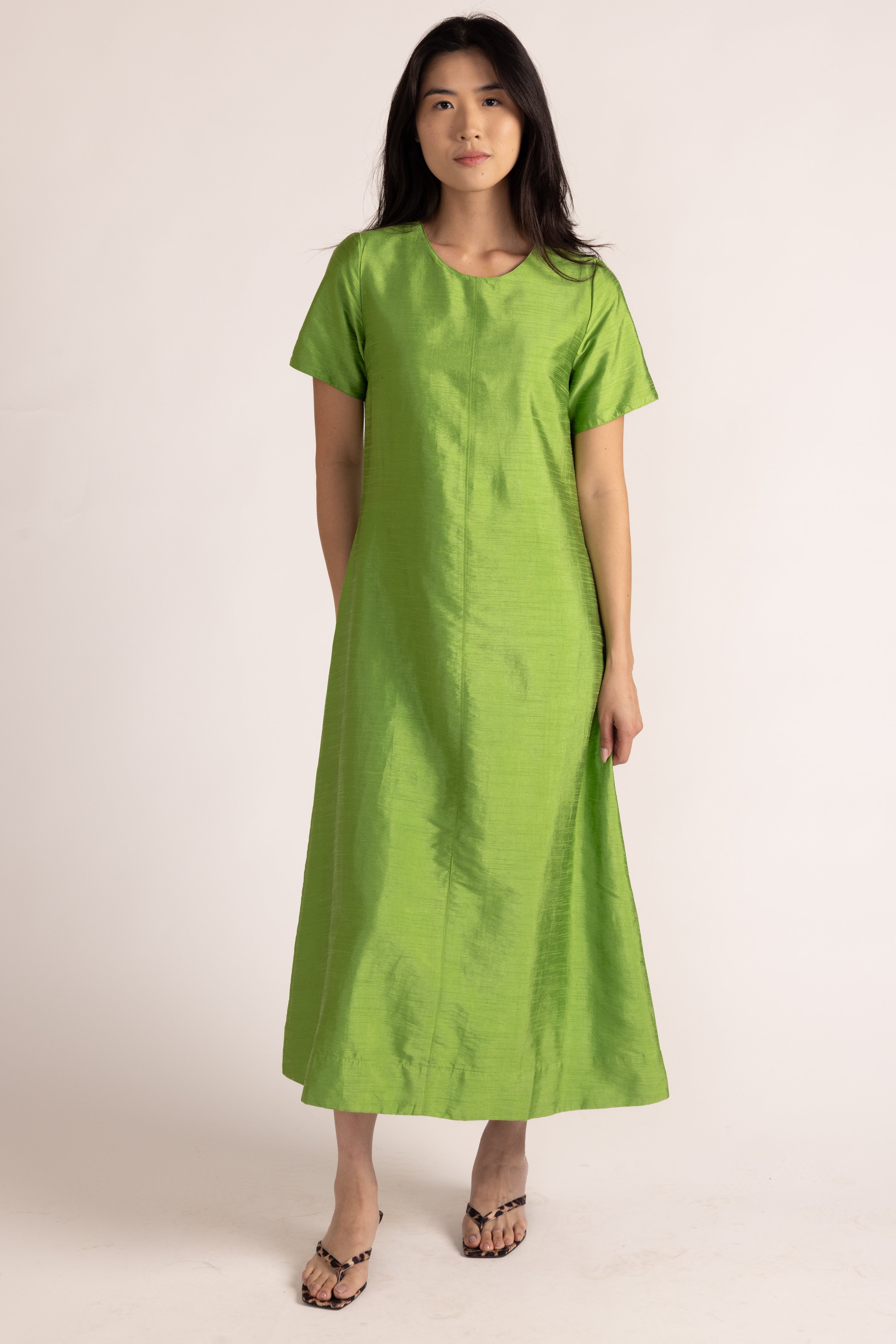 Woman wearing a green dress against a white background