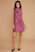 Woman wearing a sleeveless purple dress against a beige background