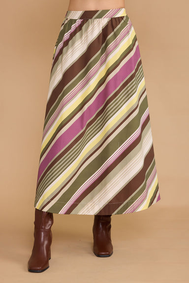 Striped skirt with brown, green, and purple pattern worn by a person on a beige background