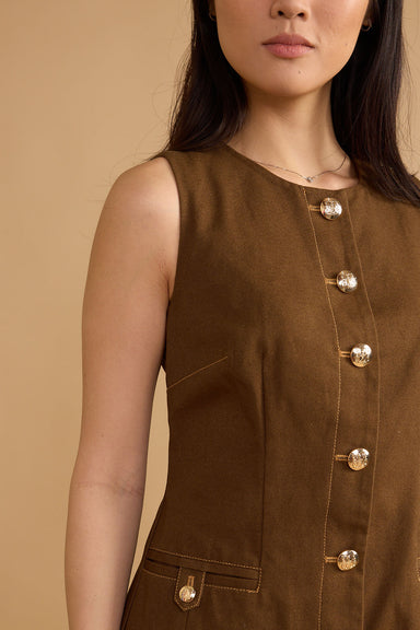 Brown sleeveless top with button details on a beige background