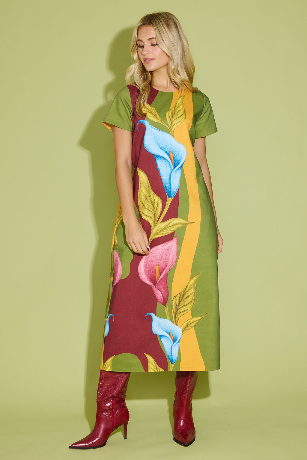 Woman wearing a colorful dress with floral design on a green background