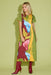 Woman wearing a colorful dress with floral design on a green background
