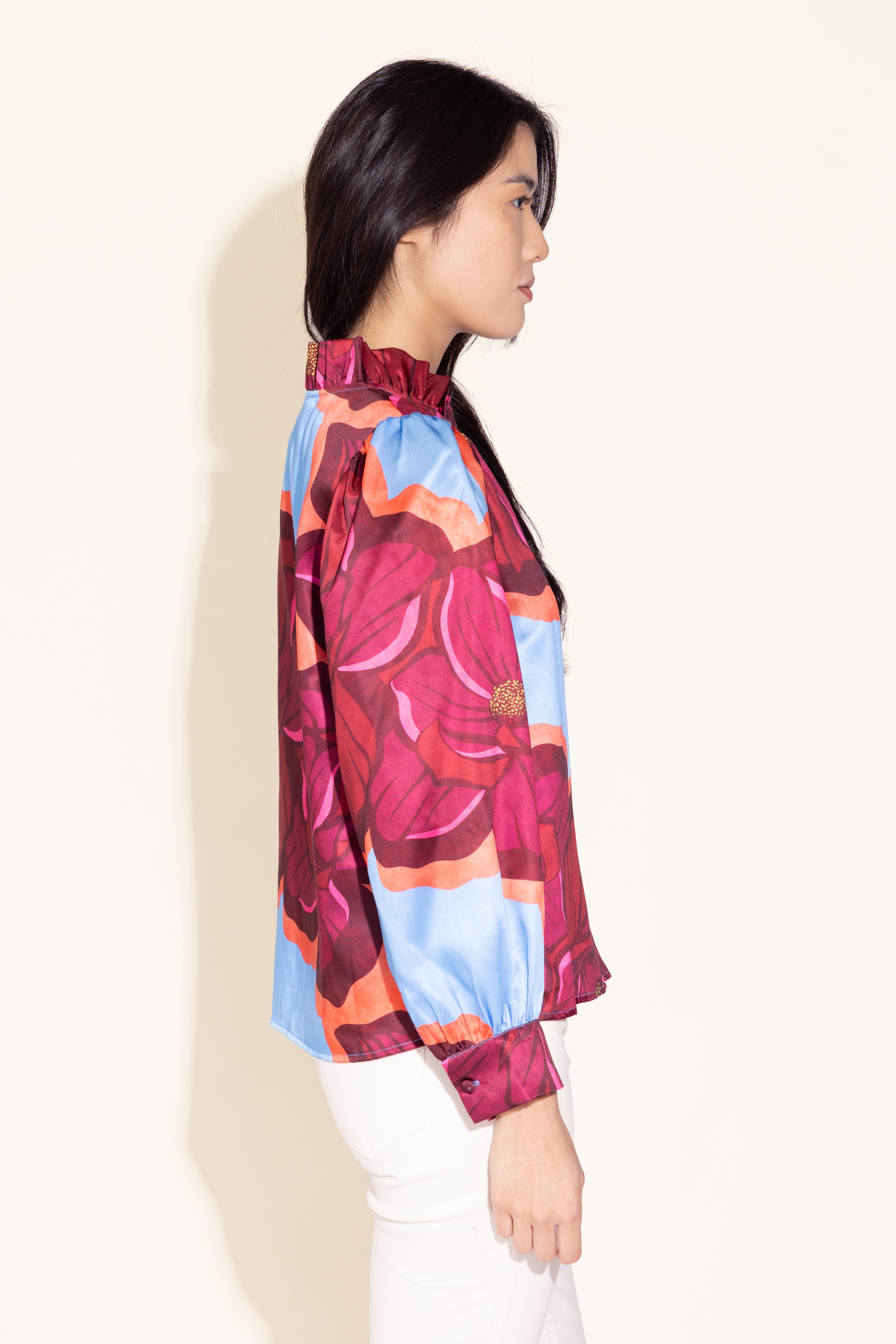 Woman wearing a colorful patterned blouse on a white background