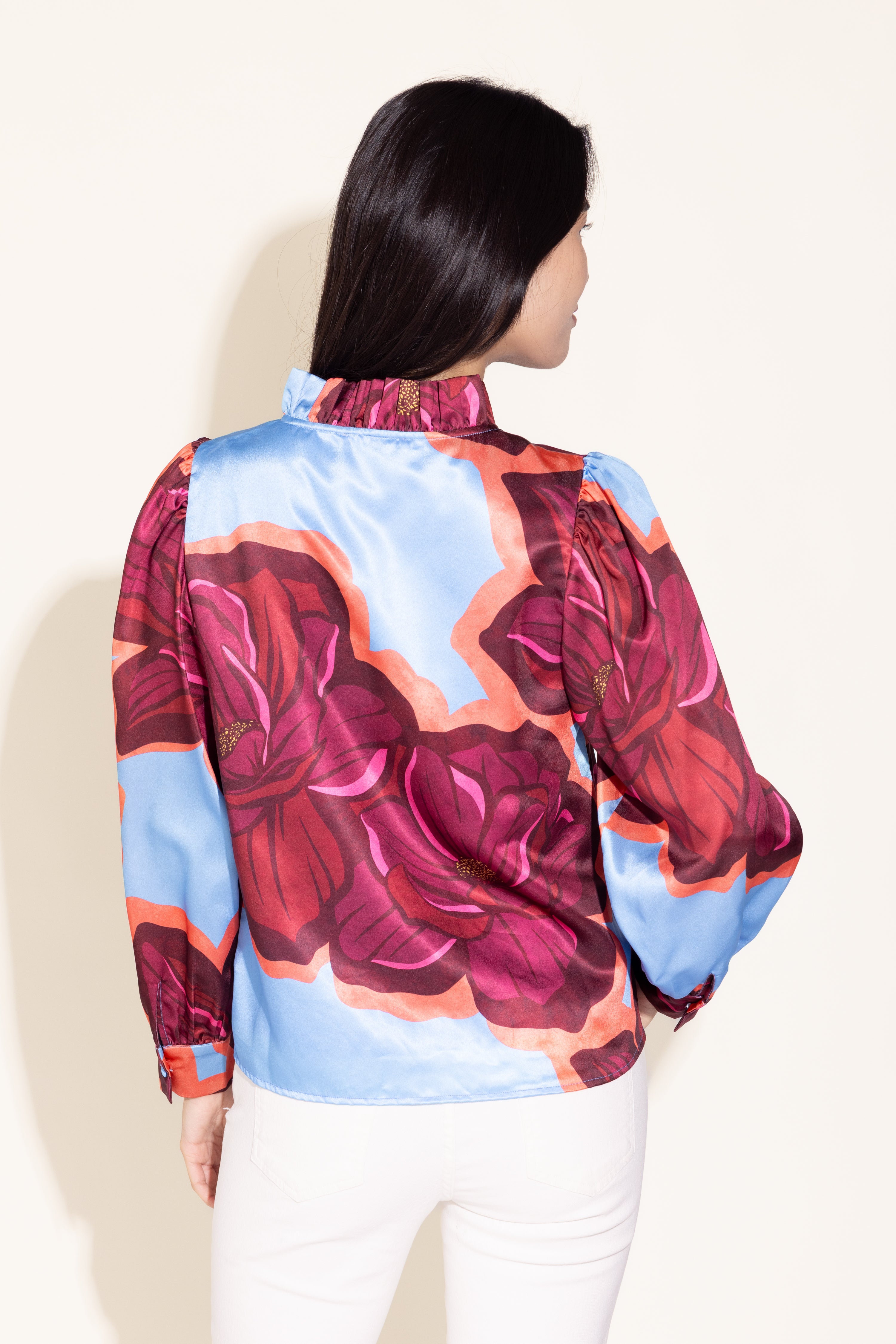 Woman wearing a colorful floral blouse with a white background